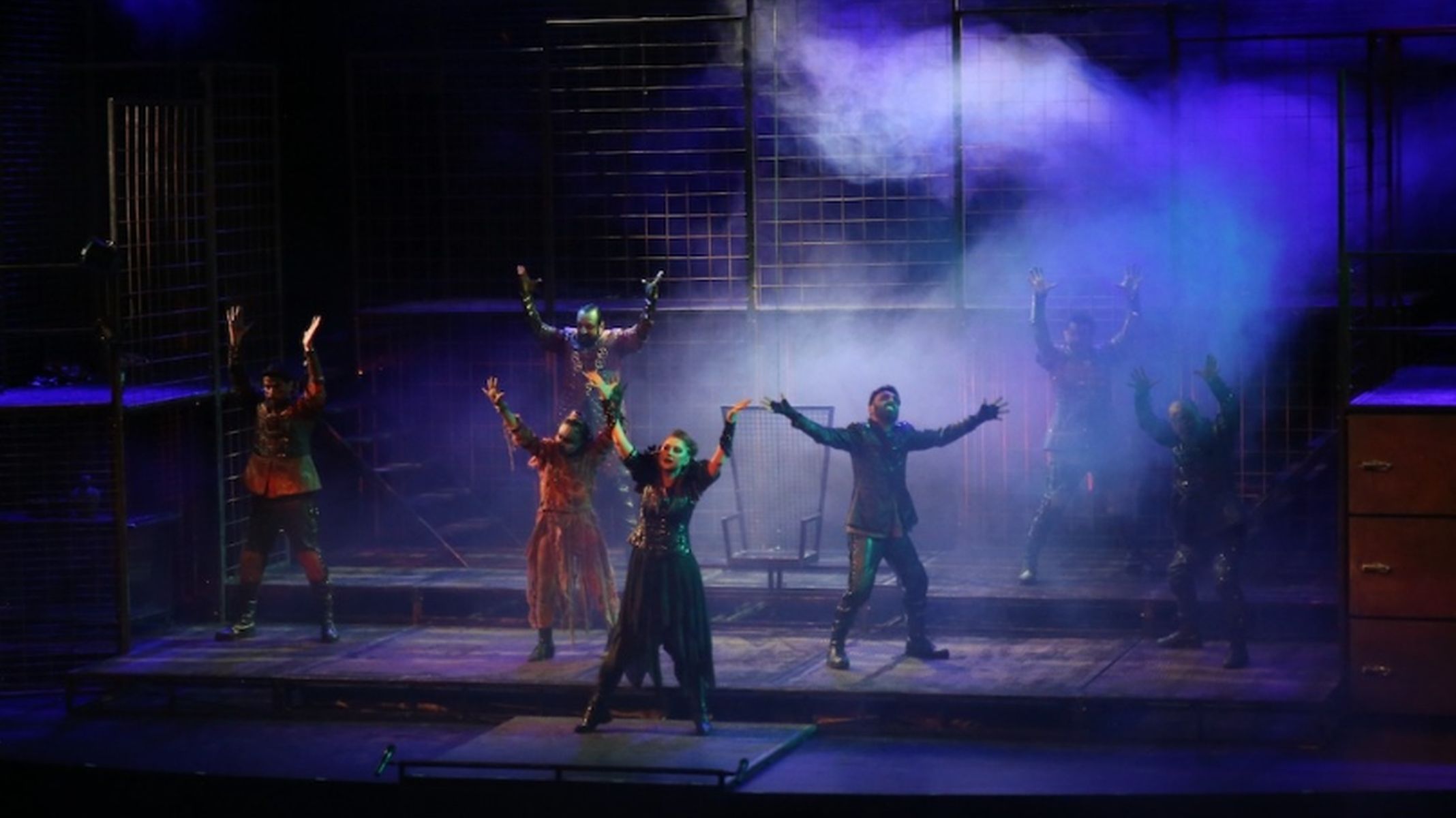 An excited audience at Eskişehir City Theaters waiting for new theater performances, surrounded by colorful play posters and vibrant theatrical lighting.